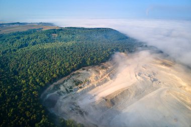 Kazı araçları ve çöp kamyonlarıyla inşaat endüstrisi için kireçtaşı malzemelerinin açık maden sahası görüntüsü