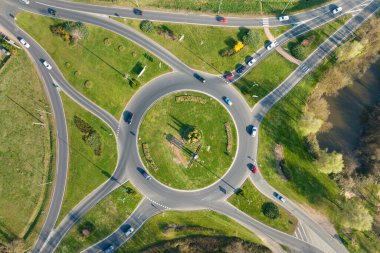 Aerial view of road roundabout intersection with moving heavy traffic. Urban circular transportation crossroads