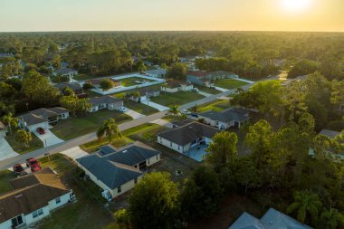 Aerial view of suburban landscape with private homes between green palm trees in Florida quiet residential area
