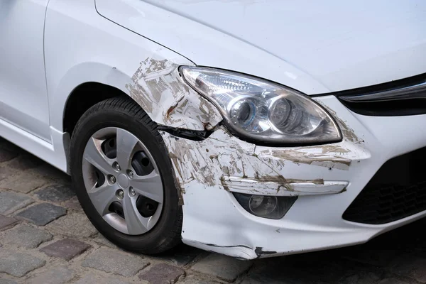 Promáčknuté auto s poškozeným nárazníkem zaparkovaným na straně ulice. Pojetí bezpečnosti silničního provozu a pojištění vozidel — Stock fotografie