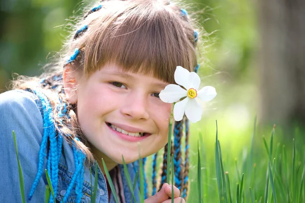 Glad barn flicka leker i sommarträdgården njuter söt doft av vita narcissus blommor på solig dag — Stockfoto