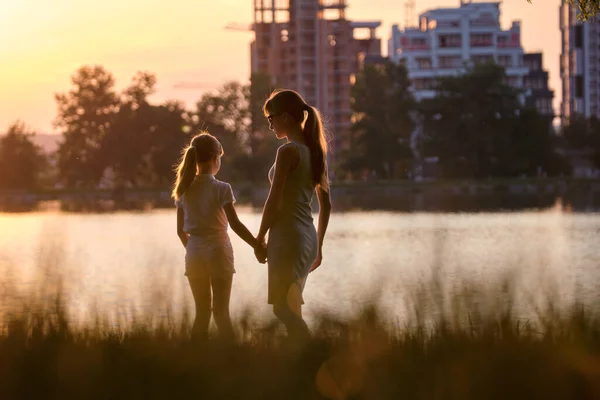 Gelukkig moeder en dochter meisje staan samen te kijken naar appartement gebouw in aanbouw dromen over hun toekomstige huis in de avond. Familie liefde en plannen over toekomstig concept — Stockfoto