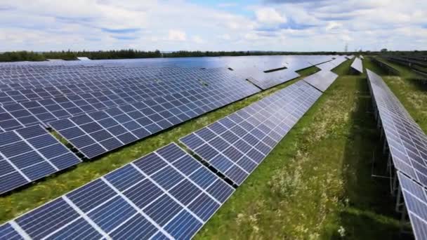 きれいな電気エネルギーを生成するための太陽光発電パネルの多くの行を持つ大規模な持続可能な電気発電所の空中ビュー。排出ゼロをコンセプトとした再生可能エネルギー — ストック動画