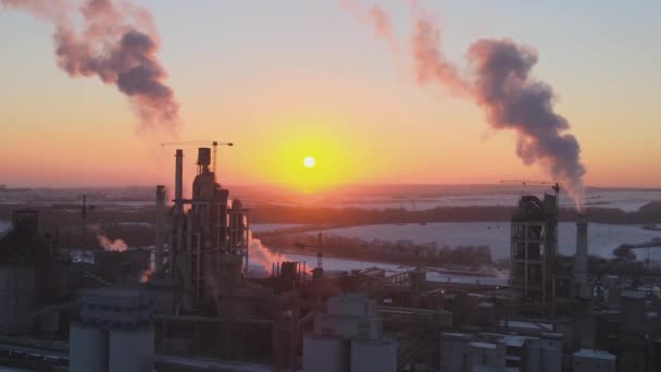日没時に工業生産エリアで高いコンクリート工場構造を持つセメント工場タワーの空中ビュー。製造業とグローバル産業の概念 — ストック動画