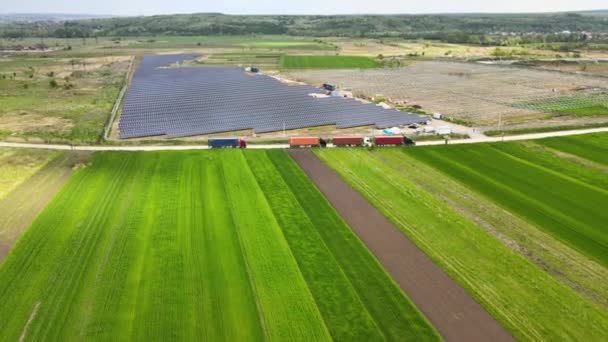 Flygfoto av elkraftverk under uppförande med lastbil som levererar monteringsdelar till solpaneler på metallram för att producera elektrisk energi. Utveckling av förnybar el — Stockvideo