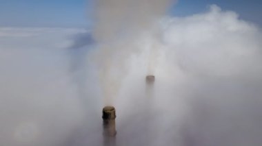 Kara dumanlı kömür santrali yüksek borular bulutların üzerinden yukarı doğru hareket ederek atmosferi kirletiyor. Fosil yakıt kavramına sahip elektrik enerjisi üretimi