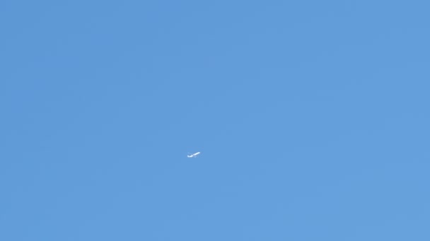 在晴朗的蓝天上高空飞行的远距离客机留下了白色的尾迹。空中运输概念 — 图库视频影像