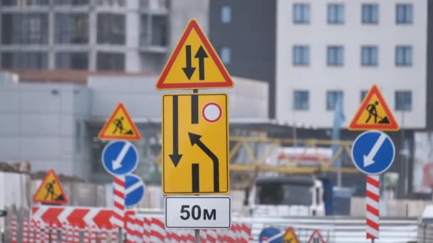 Roadworks warning traffic signs of construction work on city street and slowly moving cars — Stock Video