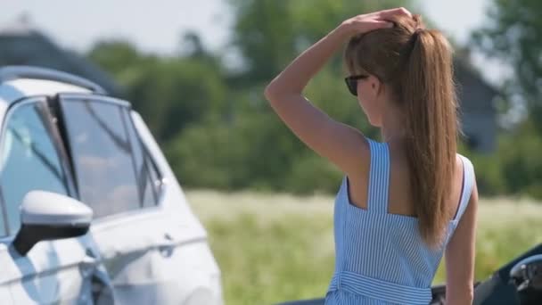 Sad female driver sitting on street side shocked after car accident. Road safety and vehicle insurance concept — Stock Video