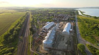 Uzun vadeli tahıl ve yağ tohumu depolamak için endüstriyel havalandırmalı siloların havadan görüntüsü. Tarım bölgesinde buğday kurutmak için metal asansör.