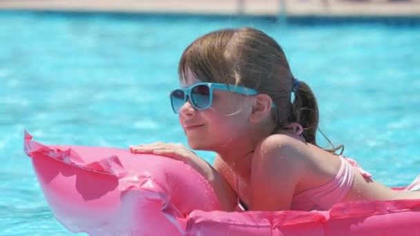 夏の太陽の下でリラックスした若い女の子は 熱帯の休暇中にプールで膨脹可能な空気マットレスで泳ぐ 夏のアクティビティコンセプト — ストック動画
