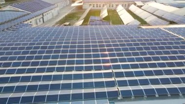 Sanayi binasının çatısına yeşil ekolojik elektrik üretmek için monte edilen mavi fotovoltaik güneş panellerinin hava görüntüsü. Sürdürülebilir enerji konsepti üretimi.