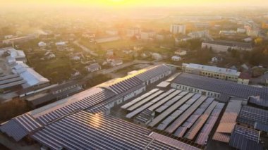 Sanayi binasının çatısına yeşil ekolojik elektrik üretmek için monte edilmiş mavi fotovoltaik panelli güneş enerjisi santralinin hava görüntüsü. Sürdürülebilir enerji konsepti üretimi.