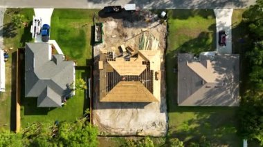 Florida 'nın sakin kırsal kesiminde yapım aşamasında olan banliyö özel evi manzaralı ahşap çatı iskeleti..