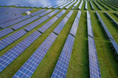 Temiz elektrik enerjisi üretmek için birçok sıra güneş fotovoltaik paneli bulunan sürdürülebilir büyük elektrik santralinin havadan görünüşü. Sıfır emisyon kavramı ile yenilenebilir elektrik.