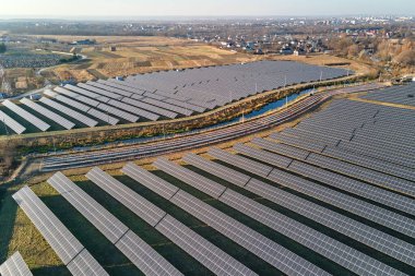 Temiz ekolojik elektrik enerjisi üretmek için sıra sıra güneş fotovoltaik panelleri olan sürdürülebilir büyük elektrik santralinin havadan görünüşü. Sıfır emisyon kavramı ile yenilenebilir elektrik.