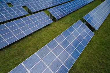 Temiz elektrik enerjisi üretmek için sıra sıra güneş fotovoltaik panelleri olan sürdürülebilir büyük elektrik santralinin havadan görünüşü. Sıfır emisyonlu yenilenebilir elektrik kavramı.