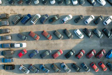 Aerial view of many colorful cars parked on dealer parking lot for sale.