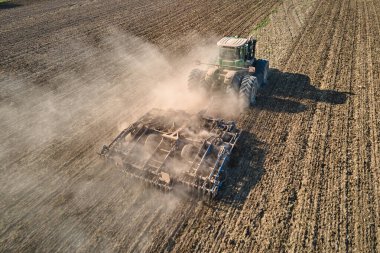 Tarım tarlasını süren traktörün havadan görünüşü yaz mevsiminde tohum ekmek için toprağı hazırlıyor..