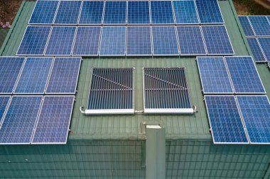Banliyö bölgesinde temiz ekolojik elektrik enerjisi üretmek için güneş fotovoltaik panellerle kaplı çatısı olan bir ev. Özerk konut kavramı.