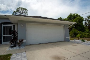 Geniş garaj, çift kapı ve modern Amerikan evinin beton yolu..