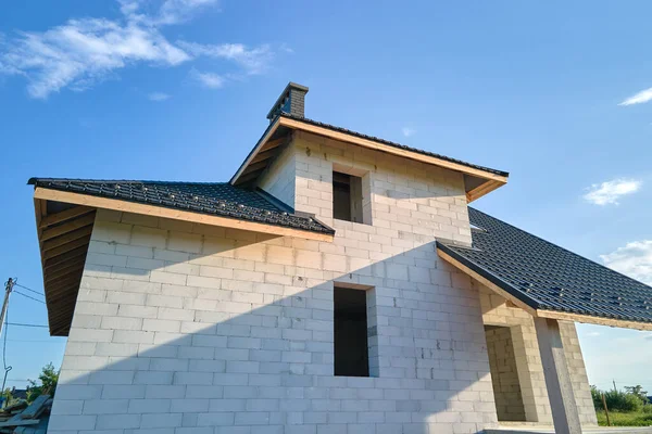 建設中の金属タイルで覆われた軽量コンクリート壁や木製の屋根フレームと未完成の家の空中ビュー — ストック写真