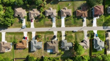 Aerial view of suburban landscape with private homes between green palm trees in Florida quiet residential area.