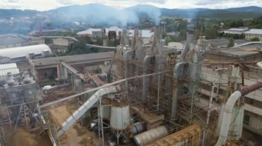 Üretim sürecinden kalma baca bacası olan ahşap işleme fabrikasının hava görüntüsü fabrika üretim sahasında çevre kirliliği yaratıyor.