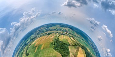 Dünya gezegeninin yüksek irtifasından yeşil ve sarı ekili tarım tarlaları ile aydınlık yaz gününde ekinlerin büyümesi..