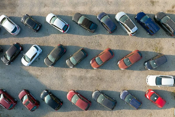 Aerial view of many colorful cars parked on dealer parking lot for sale.