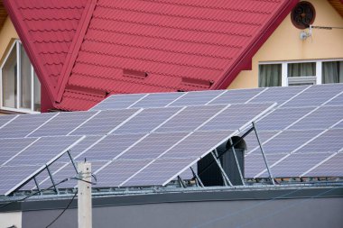 Banliyö bölgesinde temiz ekolojik elektrik enerjisi üretmek için güneş fotovoltaik panellerle kaplı çatısı olan bir ev. Özerk konut kavramı.