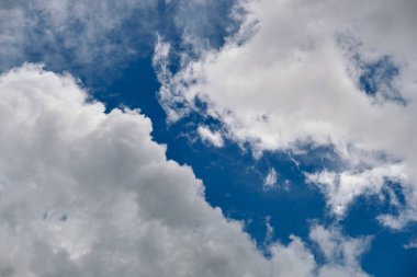 Beyaz kabarık kümülüs bulutları yaz aylarında mavi gökyüzünde.