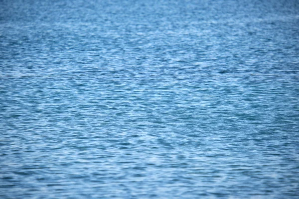 Küçük dalgalı mavi deniz suyunun yakın deniz yüzeyi.