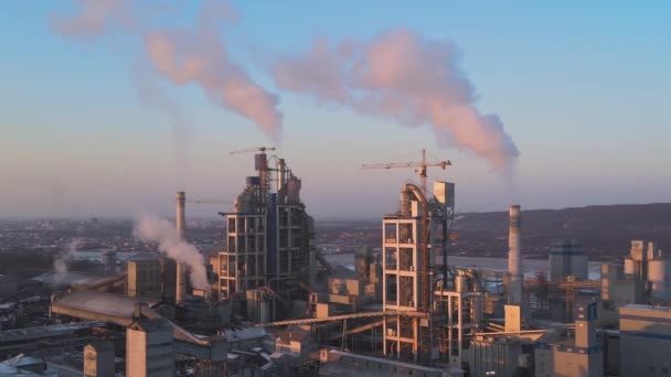 工業生産地域で高いコンクリート工場構造とタワークレーンとセメント工場の空中ビュー 温室効果ガスの煙害大気汚染 製造業とグローバル産業の概念 — ストック動画