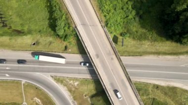 Şehir caddelerinde yoğun trafik varken kavşağın hava görüntüsü. Çok sayıda araç ve kamyonla yoğun saatlerde şehir ulaşımı.