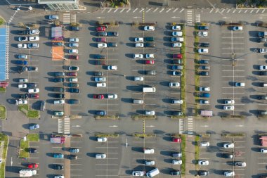 Otoparkta park yerleri ve yönler için çizgiler ve işaretlerle park edilmiş birçok renkli arabanın hava manzarası..