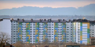 Birçok pencere ve balkonu olan modern yüksek apartman cephesinin mimari ayrıntıları.