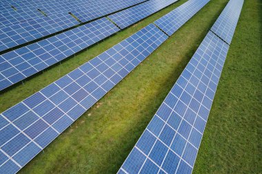 Temiz elektrik enerjisi üretmek için sıra sıra güneş fotovoltaik panelleri olan sürdürülebilir büyük elektrik santralinin havadan görünüşü. Sıfır emisyonlu yenilenebilir elektrik kavramı.