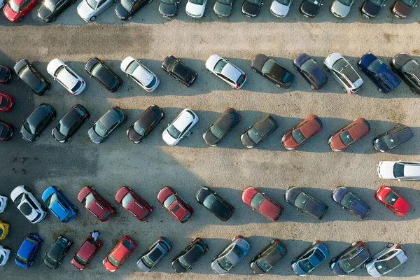 Aerial view of many colorful cars parked on dealer parking lot for sale.