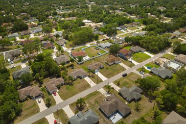 Aerial landscape view of suburban private houses between green palm trees in Florida quiet rural area.