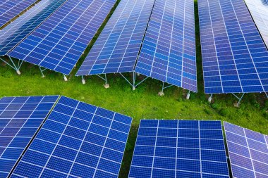 Temiz ekolojik elektrik enerjisi üretmek için sıra sıra güneş fotovoltaik panelleri olan sürdürülebilir büyük elektrik santralinin havadan görünüşü. Sıfır emisyon kavramı ile yenilenebilir elektrik.