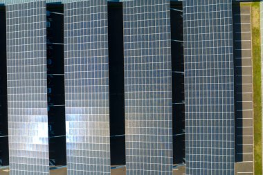 Güneş panellerinin hava görüntüsü park yerinin üzerine gölge çatısı olarak yerleştirilmiş ve temiz elektriğin etkin üretimi için park edilmiş arabalar var. Fotovoltaik teknoloji şehir altyapısına entegre edildi.