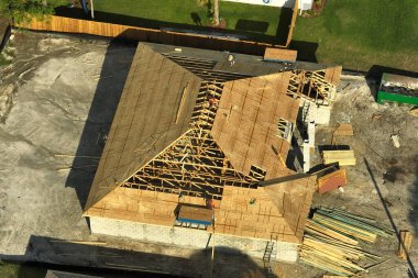 Florida 'nın sakin kırsal kesiminde yapım aşamasında olan banliyö özel evi manzaralı ahşap çatı iskeleti..