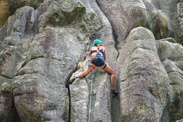 岩の多い山の急な壁を登る少女登山を決定した 難しいルートを克服するスポーツ女性 極端なスポーツやロッククライミングの趣味の概念に従事 — ストック写真
