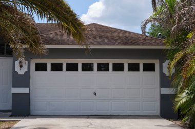 Geniş garaj, çift kapı ve modern Amerikan evinin beton yolu..