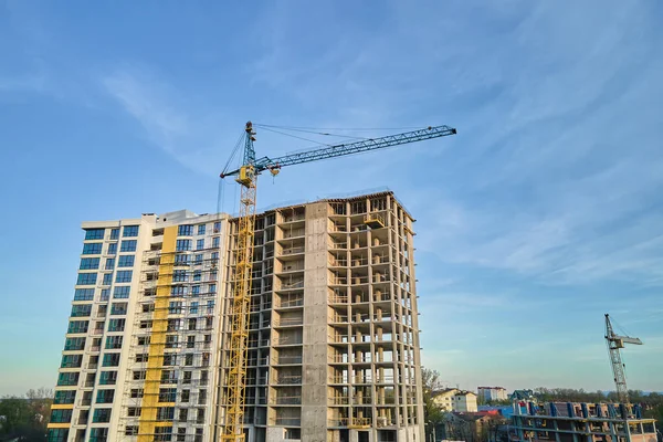 Tower cranes at high residential apartment buildings construction site. Real estate development.