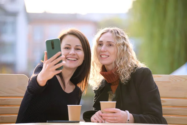Две Счастливые Женщины Делают Селфи Мобильным Телефоном Сидя Кафе Городской — стоковое фото