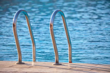 Yüzme havuzuna yakın paslanmaz çelik korkuluklar kaplumbağaların temiz havuz suyuna iniyor. Eğlence etkinlikleri kavramının erişilebilirliği.