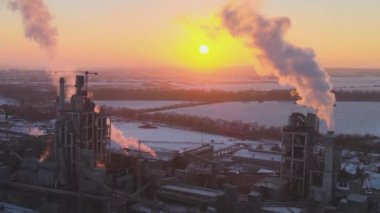 Gün batımında endüstriyel üretim alanında yüksek beton yapılı çimento fabrikası kulesinin havadan görüntüsü. Üretim ve küresel sanayi kavramı.