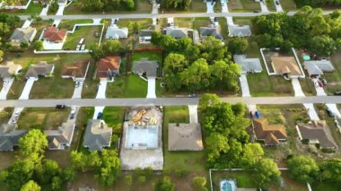 Florida 'nın sakin yerleşim bölgesinde yeşil palmiye ağaçları arasında özel evleri olan küçük bir Amerikan banliyö manzarası..